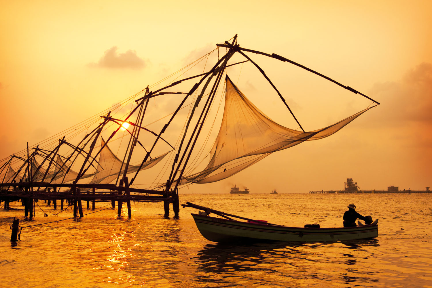 Sunset-over-Chinese-Fishing-nets-and-boat-in-Cochin-Kochi-Kerala-India-shutterstock_104171129